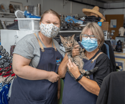 Volunteers with a cat at the op shop
